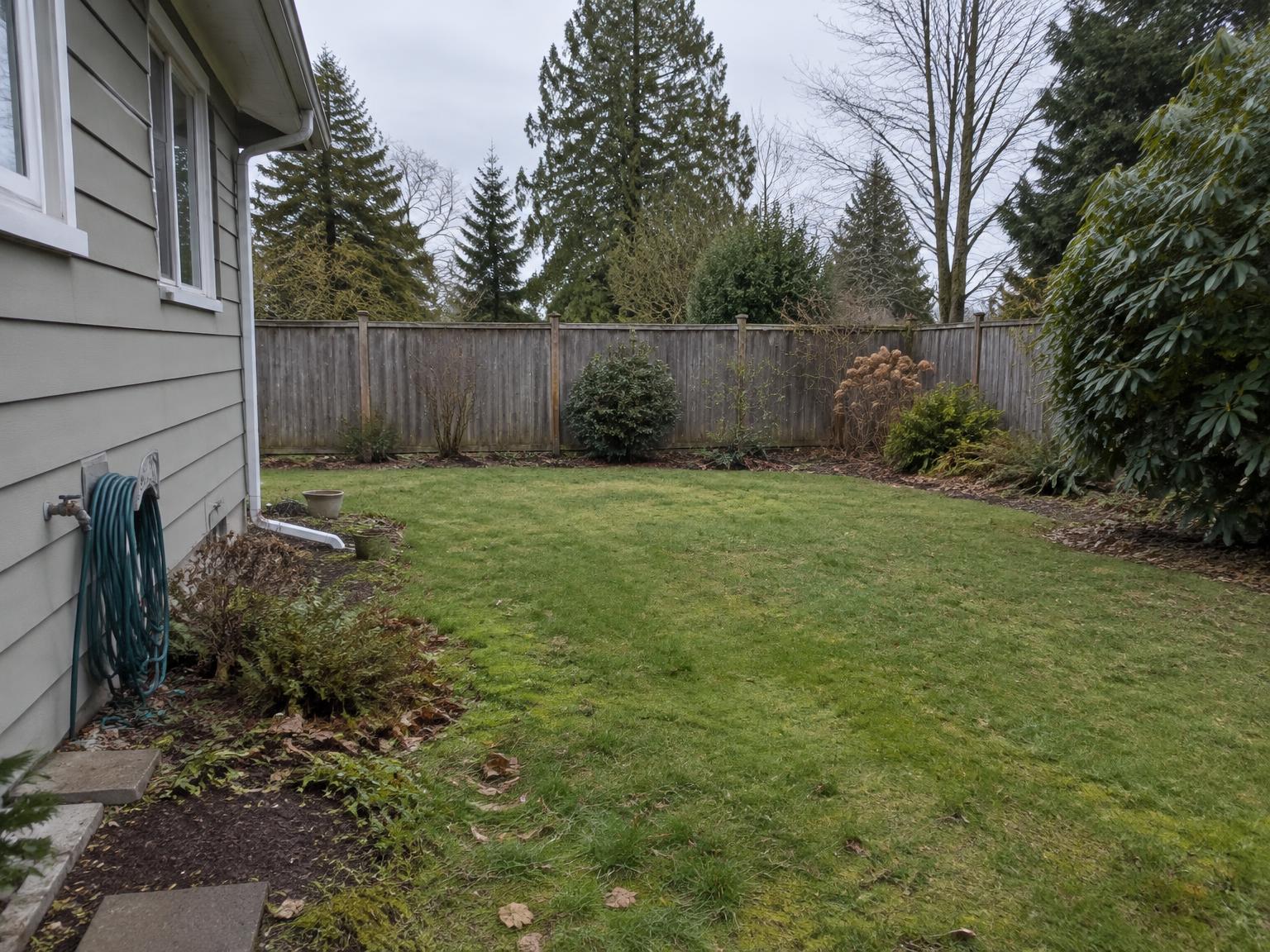 The back garden of a detached house, showing the depth of the lot to the fence line