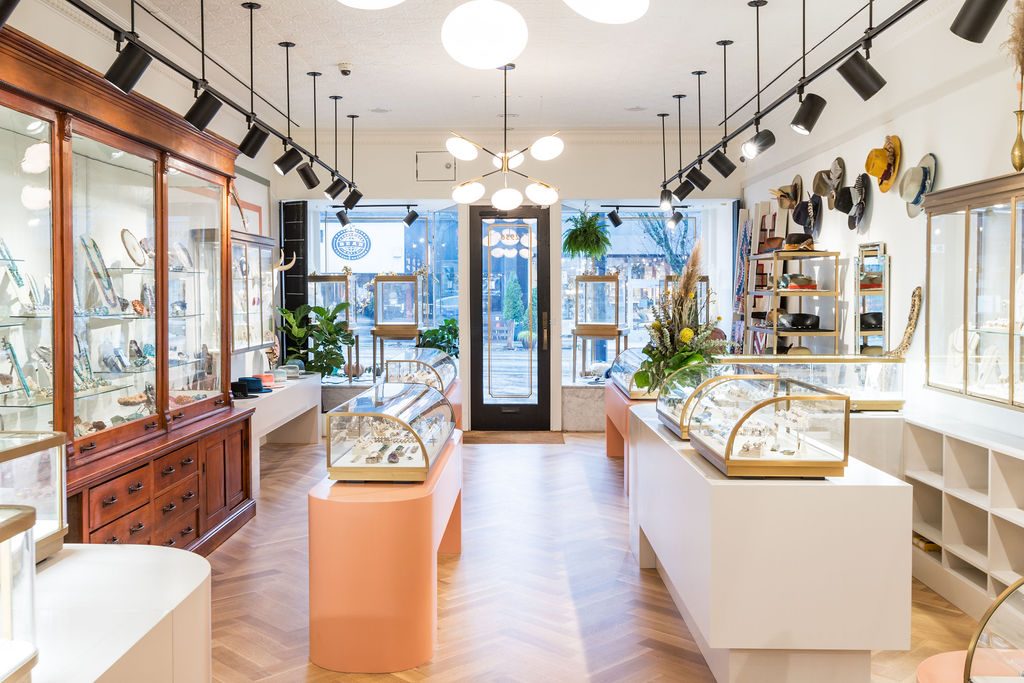 A shop interior seen down its full length toward the front door, with fitted display cases