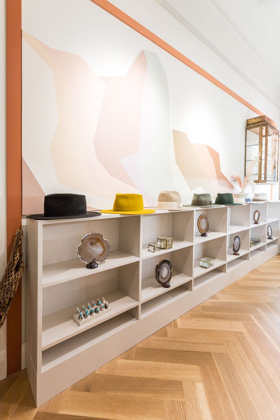 A long low run of fitted display shelving beneath a painted wall